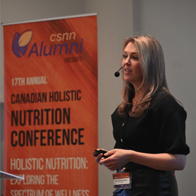 jessa speaking on stage at csnn alumni event